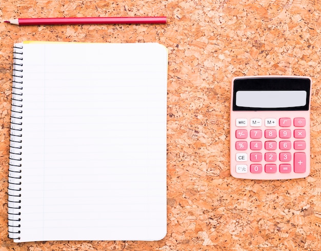 Calculator near notebook and pencil