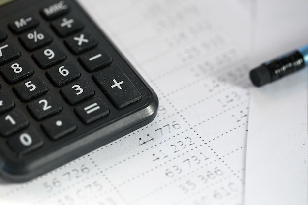 Calculator and pencil closeup on a blurred background