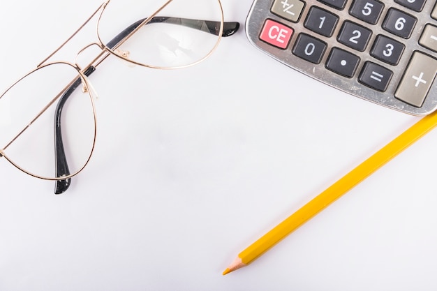 Free photo calculator with glasses on table