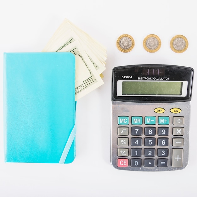 Calculator with money and notebook on table