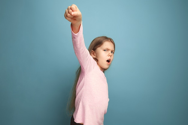 Free photo the call for struggle. teen girl on a blue. facial expressions and people emotions concept