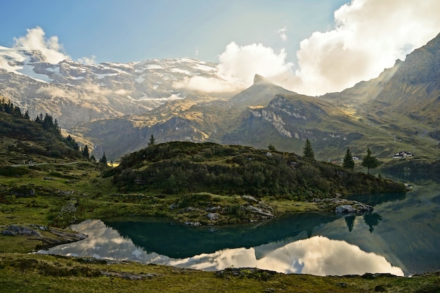 Calm body of water surrounded by mountains during daytime