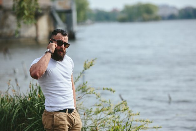 Calm man talking on the phone with lake background