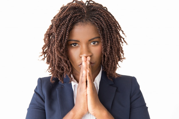 Calm serious female making pray gesture