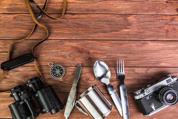 Free photo camera and binocular with kitchen utensils on wooden table