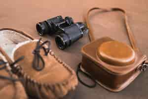 Free photo camera and binoculars near shoes