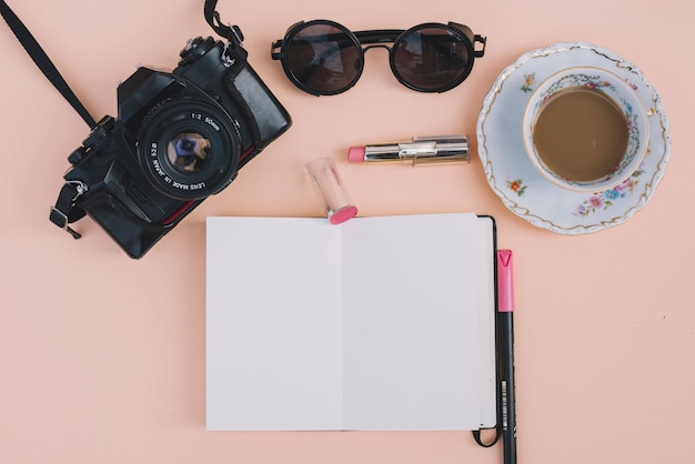 Camera and coffee near notebook and accessories