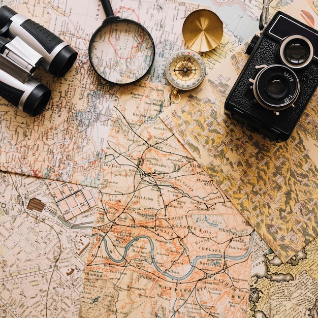 Camera and compass near magnifying glass and binoculars