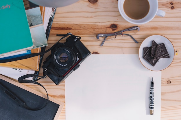 Free photo camera and glasses near paper sheet and snack