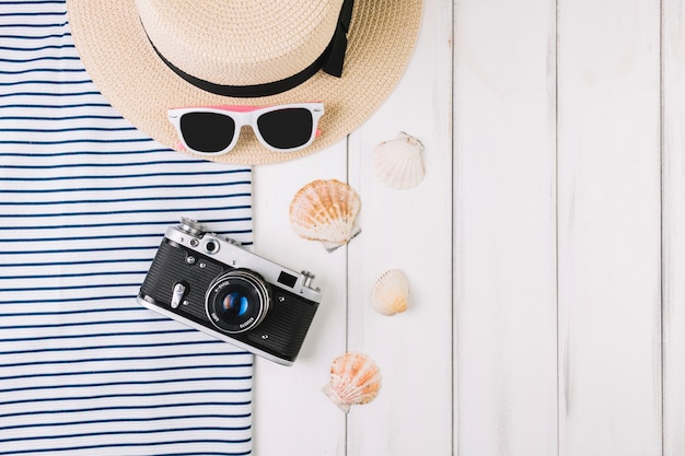 Free photo camera and seashells near hat and sunglasses