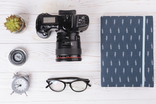 Camera with notebook on wooden table