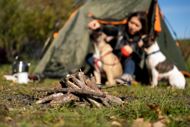 Campfire front view and blurred woman playing with dogs