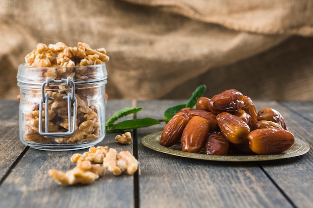 Free photo can with nuts near plant twig and dried fruits on table