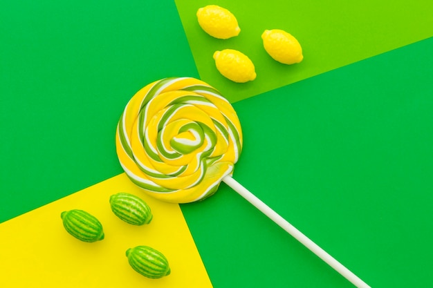 Free photo candies and lollipop on contract colored paper background