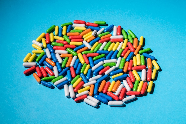 Free photo candies in the shape of capsules over the blue background