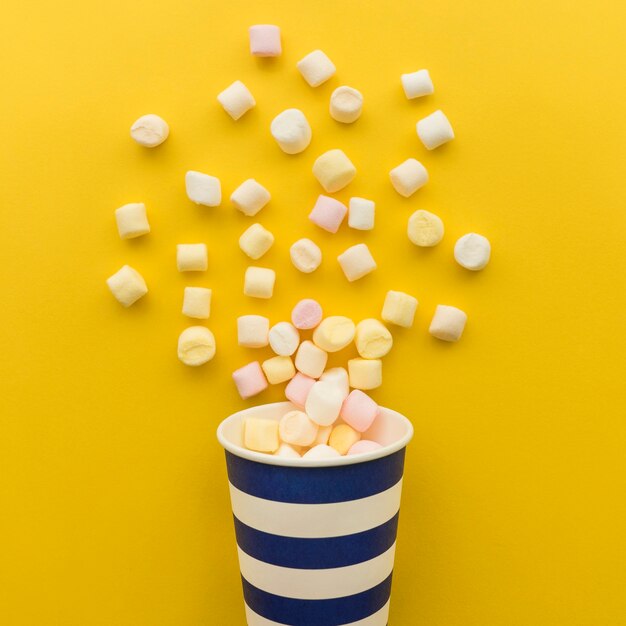 Candy falling out of paper cup close up