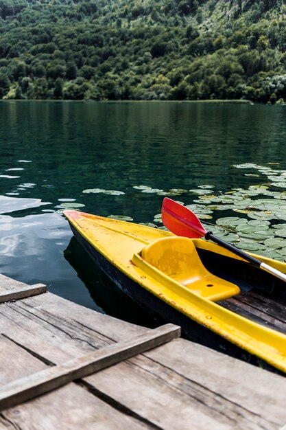 Canoe floating near the wooden pier on lake