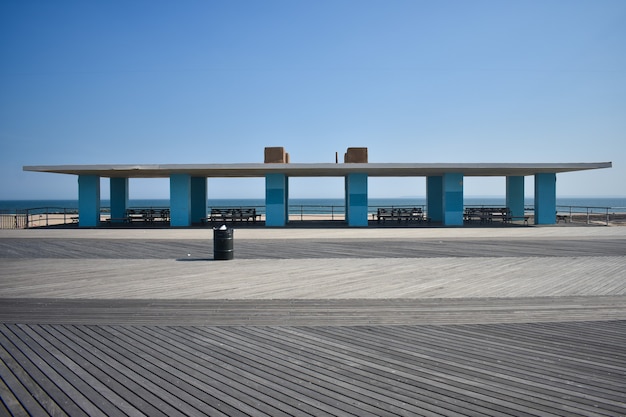 Free photo canopy building at the beach with blue columns, white roof and benches