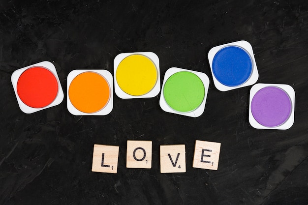 Free Photo cans of rainbow colors and text of love