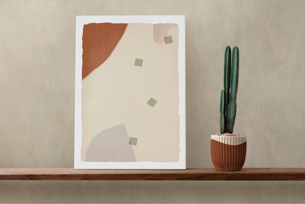 Canvas wall art on a wooden shelf with cactus