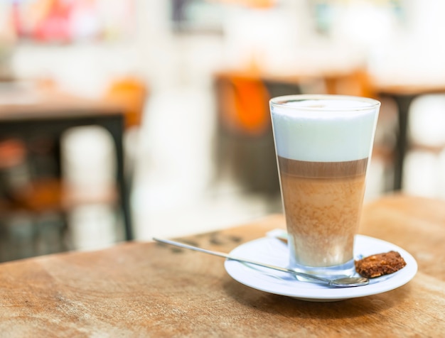 Cappuccino coffee in a transparent glass on table