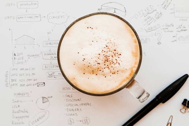 Free Photo cappuccino cup in middle of business plan paper