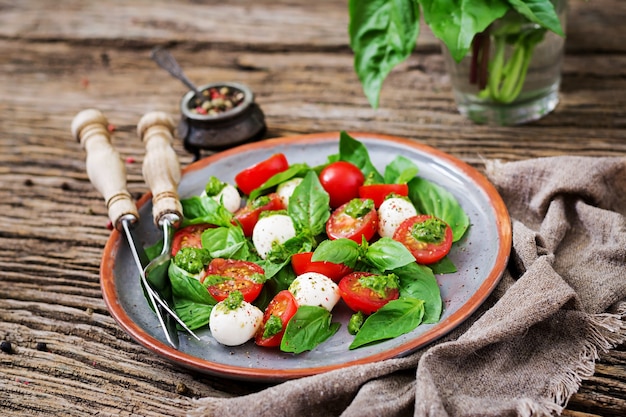 Caprese salad. Healthy meal with cherry tomatoes, mozzarella balls and basil. Home made, tasty food.  Concept for a tasty and healthy vegetarian meal.