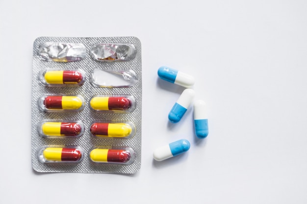 Capsules and drug blister pack on white background