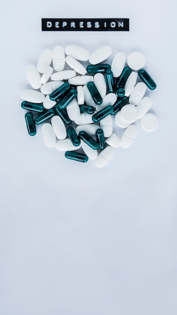 Capsules with various pills near depression label over grey background