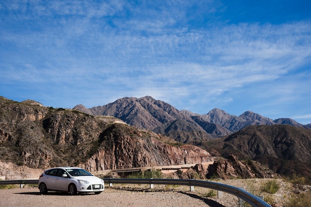 Free photo car in front of mountain landscape