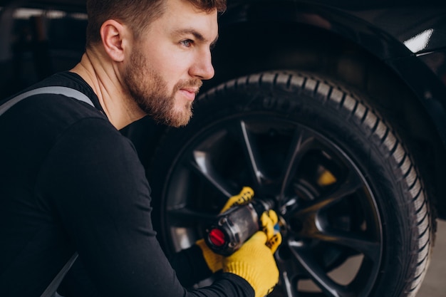 Free Photo car mechanic changing wheels in car