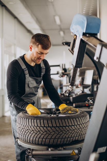 Free photo car mechanic changing wheels in car