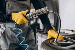 Free photo car mechanic changing wheels in car