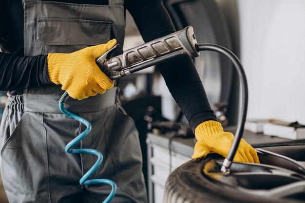 Car mechanic changing wheels in car