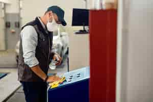 Free photo car mechanic disinfecting machines in auto repair shop during coronavirus pandemic