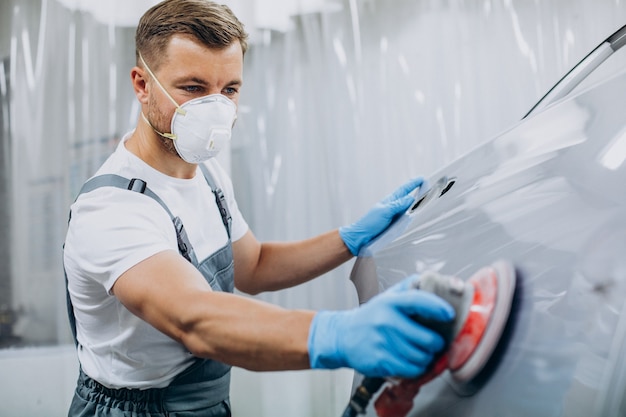 Free photo car mechanic polishing car before painting