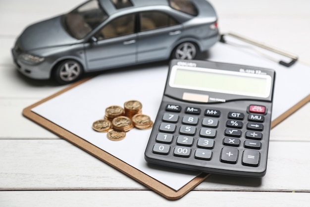 Free photo car model,calculator and coins on white table