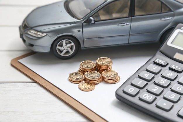 Free photo car model,calculator and coins on white table