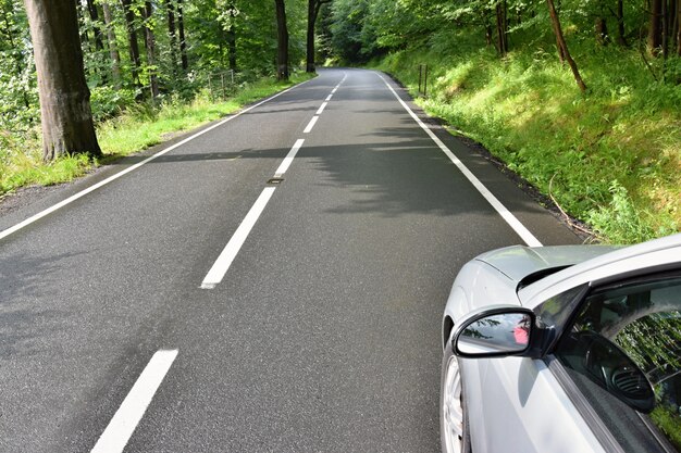 "Car parked on roadside in woods"