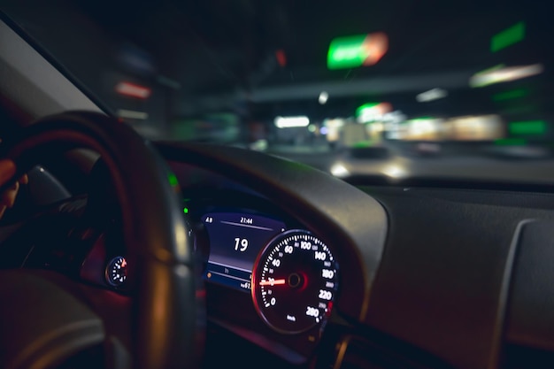 Car steering wheel and view of the night road from the car closeup