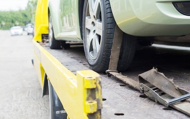 Free photo car transporter breakdown lorry during working using locked belt transport other green car