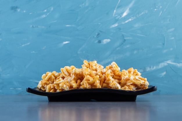 Free photo caramel candies on a plate on the marble surface