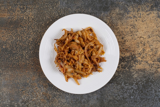 Free photo caramelized onion pieces on white plate.