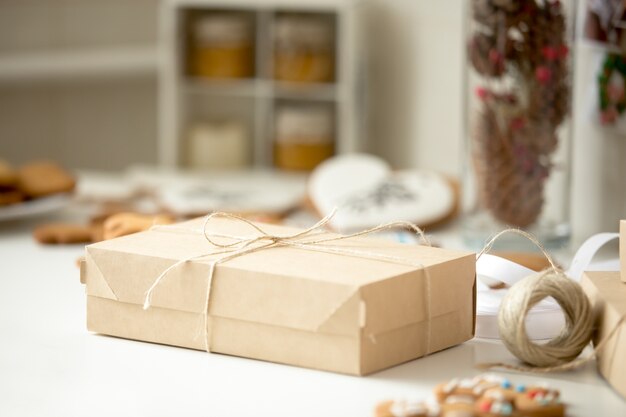 Cardboard box, postal parcel wrapped in brown kraft paper tied