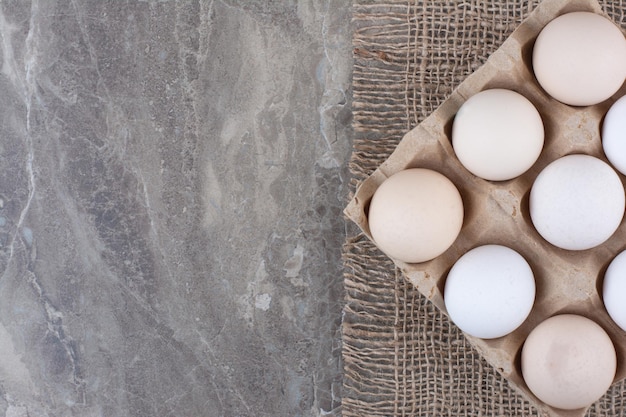 Free photo cardboard box with white chicken eggs and feather. high quality photo