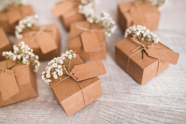 Free Photo cardboard gift boxes with tag and baby's-breath flowers on wooden desk