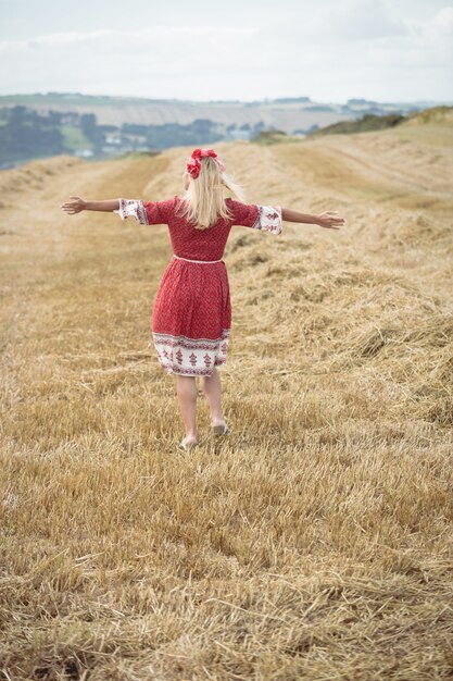 Carefree blonde woman standing in field