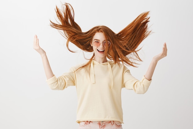 Free photo carefree gorgeous redhead girl throwing hair up in air