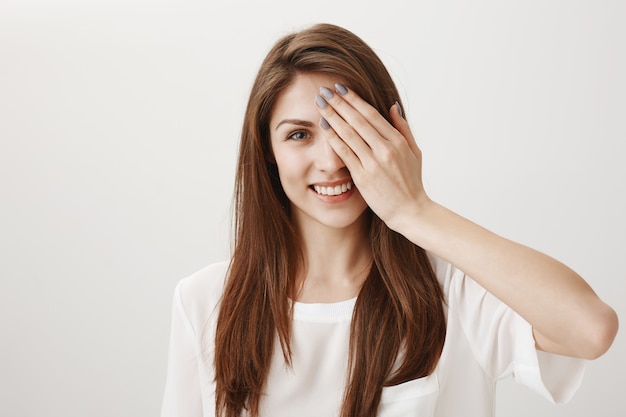 Carefree happy woman cover half of face and smiling pleased