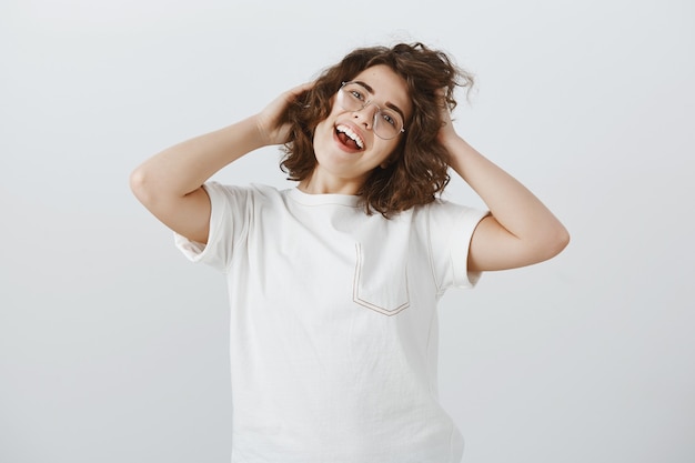 Free Photo carefree happy woman in glasses touching her new haircut with pleased face